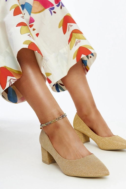 Złote świecące czółenka na słupku Laity