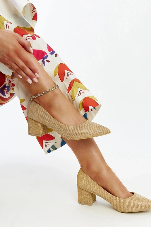 Złote świecące czółenka na słupku Laity