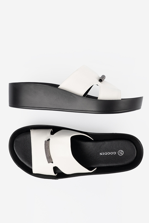 INhite-black slippers on a loIn Inedge