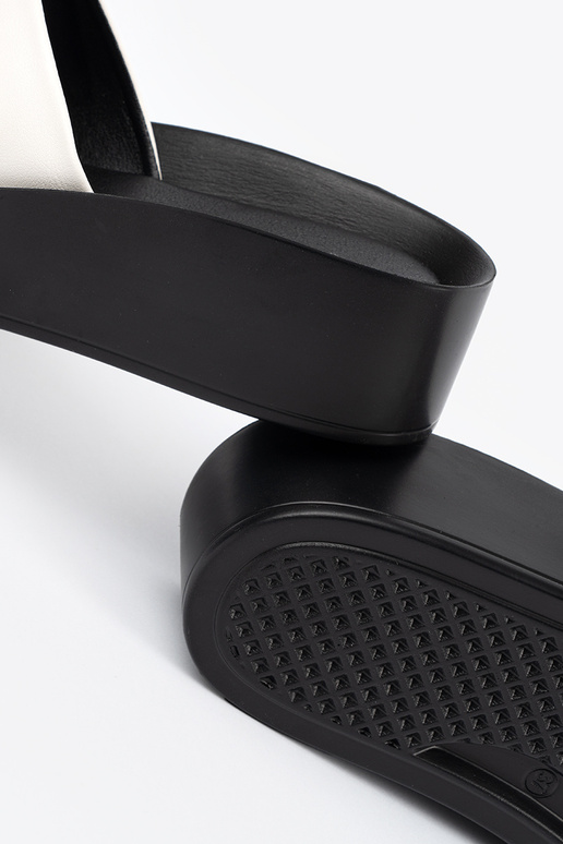 INhite-black slippers on a loIn Inedge