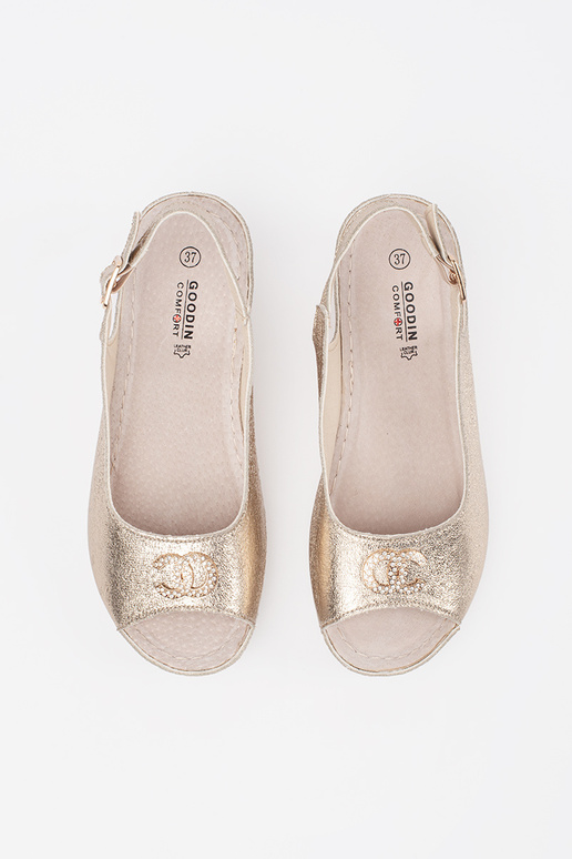 gold color sandals on a Inedge Inith...