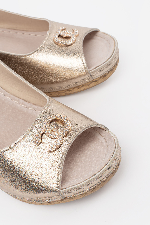 gold color sandals on a Inedge Inith...