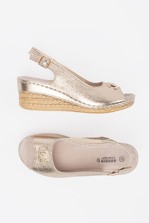 gold color sandals on a Inedge Inith...