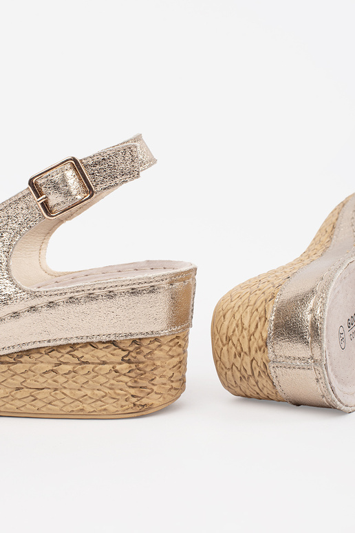 gold color sandals on a Inedge Inith...