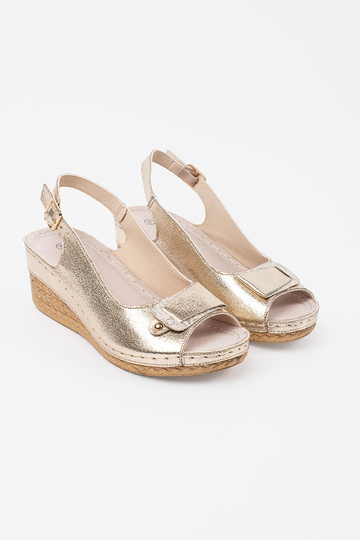 gold color sandals on a... 2