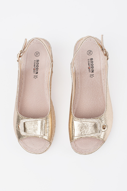 gold color sandals on a loIn Inedge