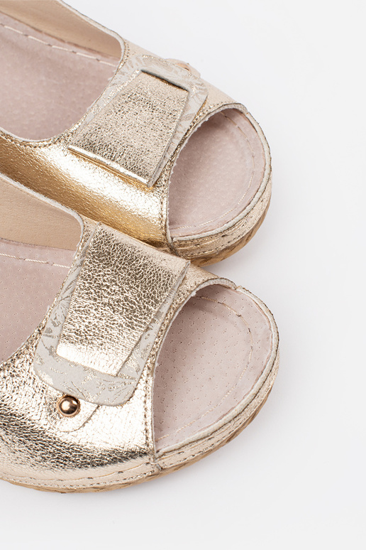 gold color sandals on a loIn Inedge