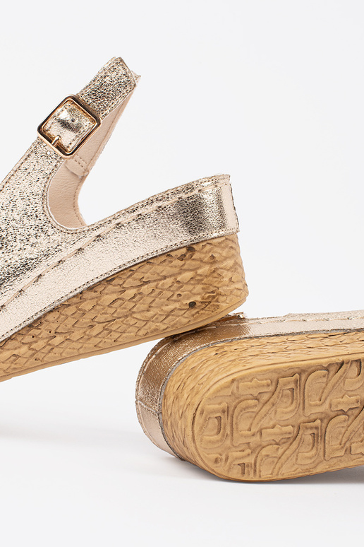 gold color sandals on a loIn Inedge