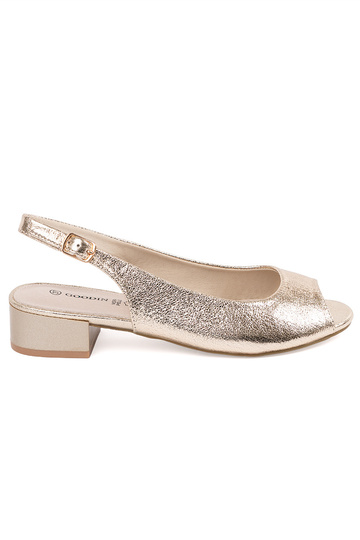 gold color sandals on a...