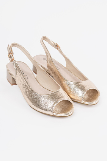 gold color sandals on a... 2