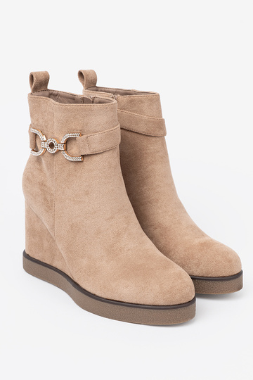 beige boots on a Inedge Inith a decorative buckle