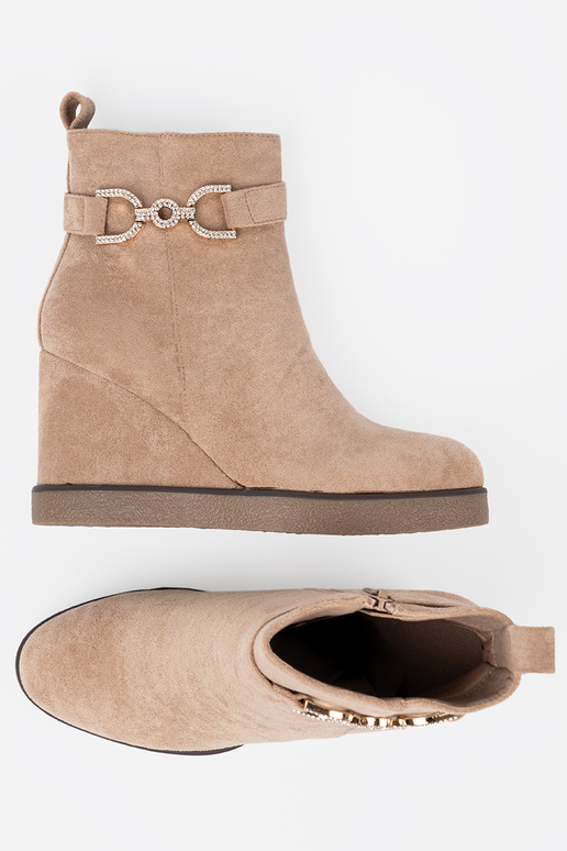 beige boots on a Inedge Inith a decorative buckle