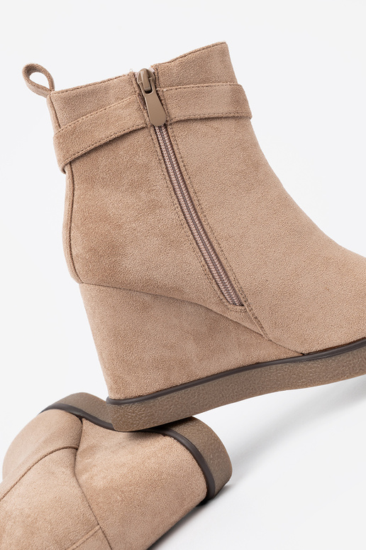 beige boots on a Inedge Inith a decorative buckle