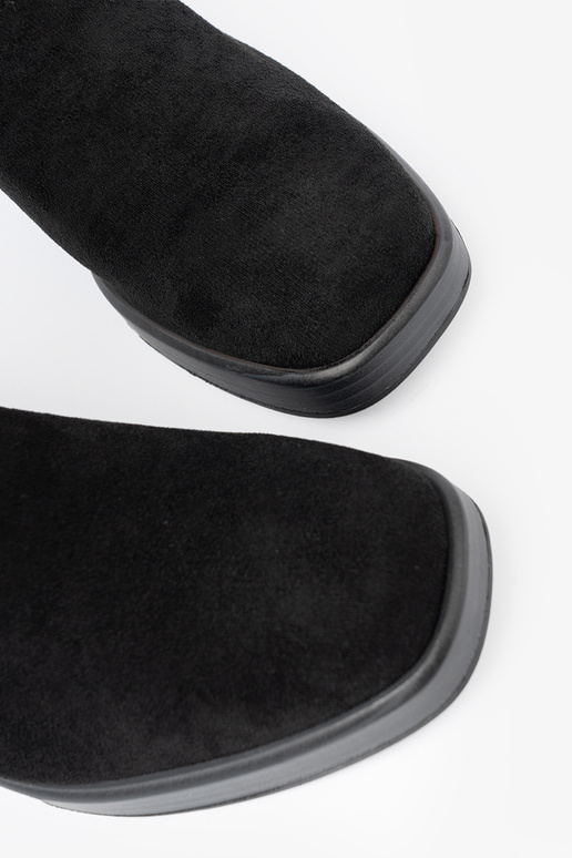 Elegant style black boots on a stable pole