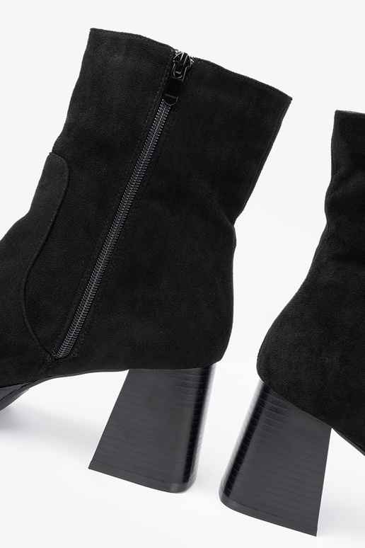 Elegant style black boots on a stable pole