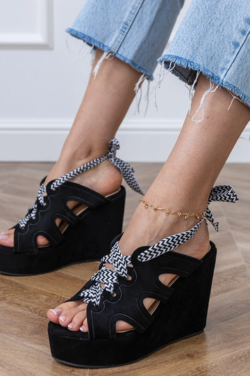 Black sandals on a platform with a decorative lace Lakota
